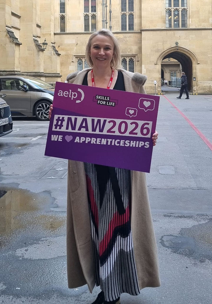 Jenny Pelling Kaplan’s Jenny Pelling stood by the Houses of Parliament holding a National Apprenticeship Week 2026 sign